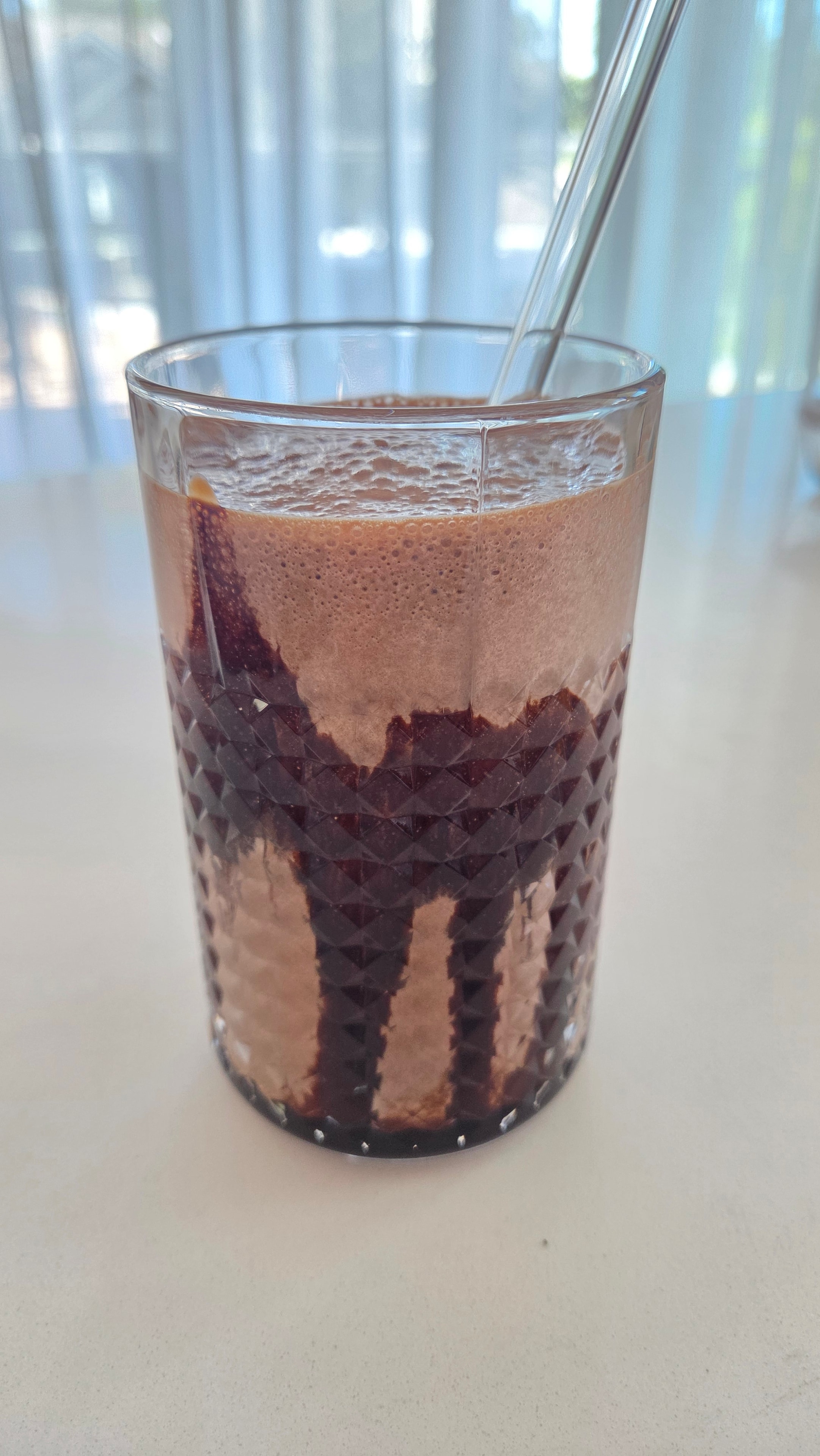 Hershey's chocolate syrup drizzled and coating the inside of the glass before the smoothie is poured in