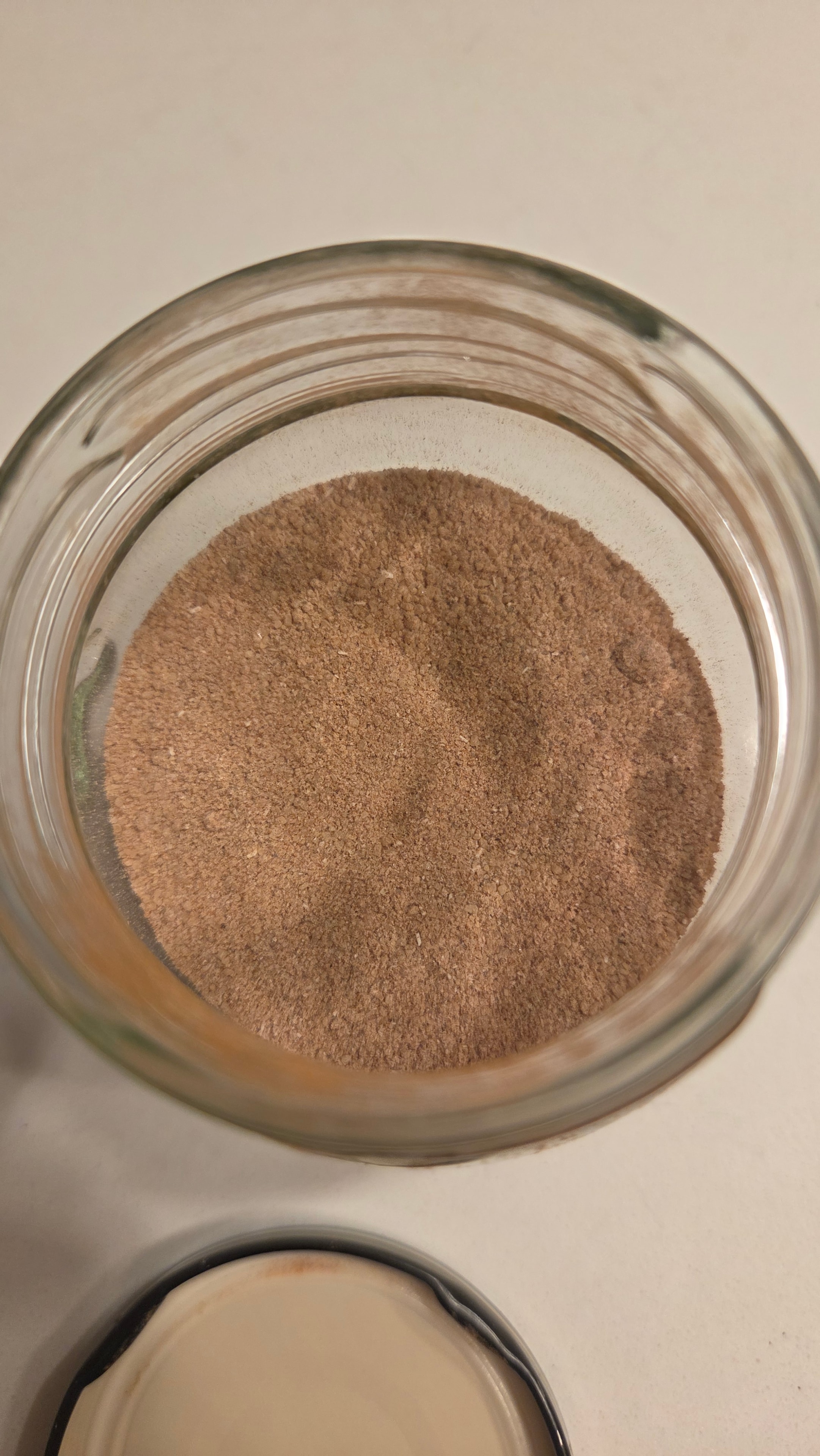 Fine cinnamon sugar powder in a glass jar — the blended dry mix of brown sugar, cinnamon, and vanilla sugar