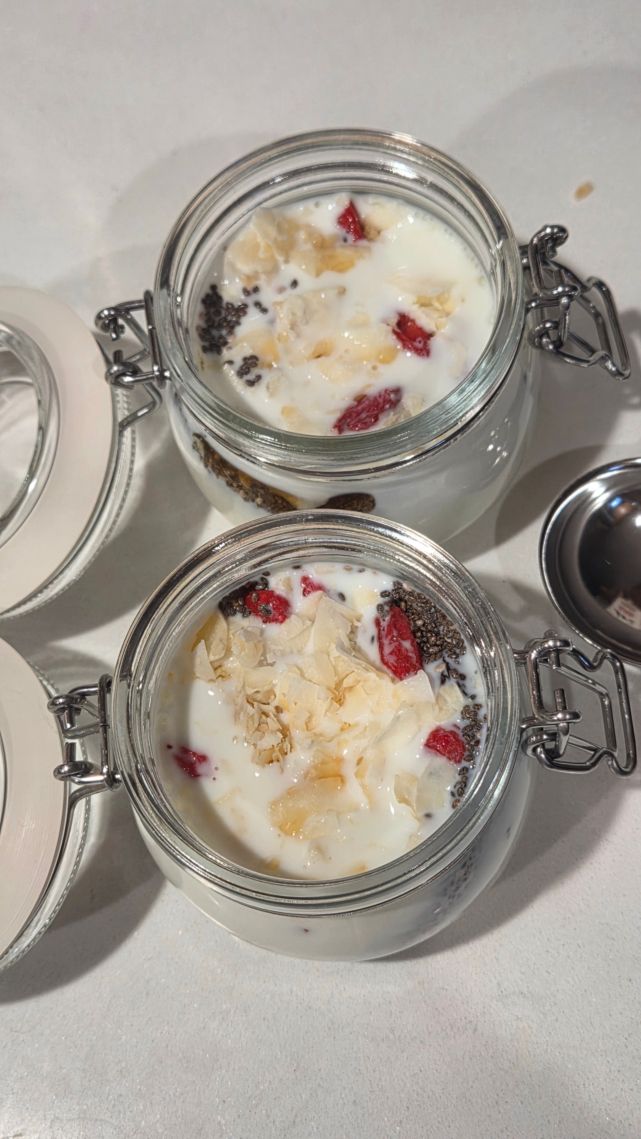 Jars filled with milk and all ingredients, viewed from above before stirring